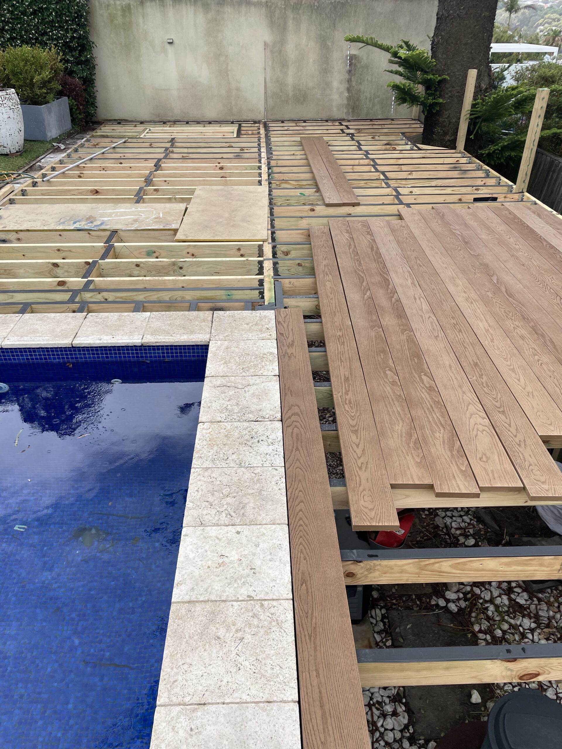 Millboard decking boards installation begins, Clovelly pool deck — The Decksmith