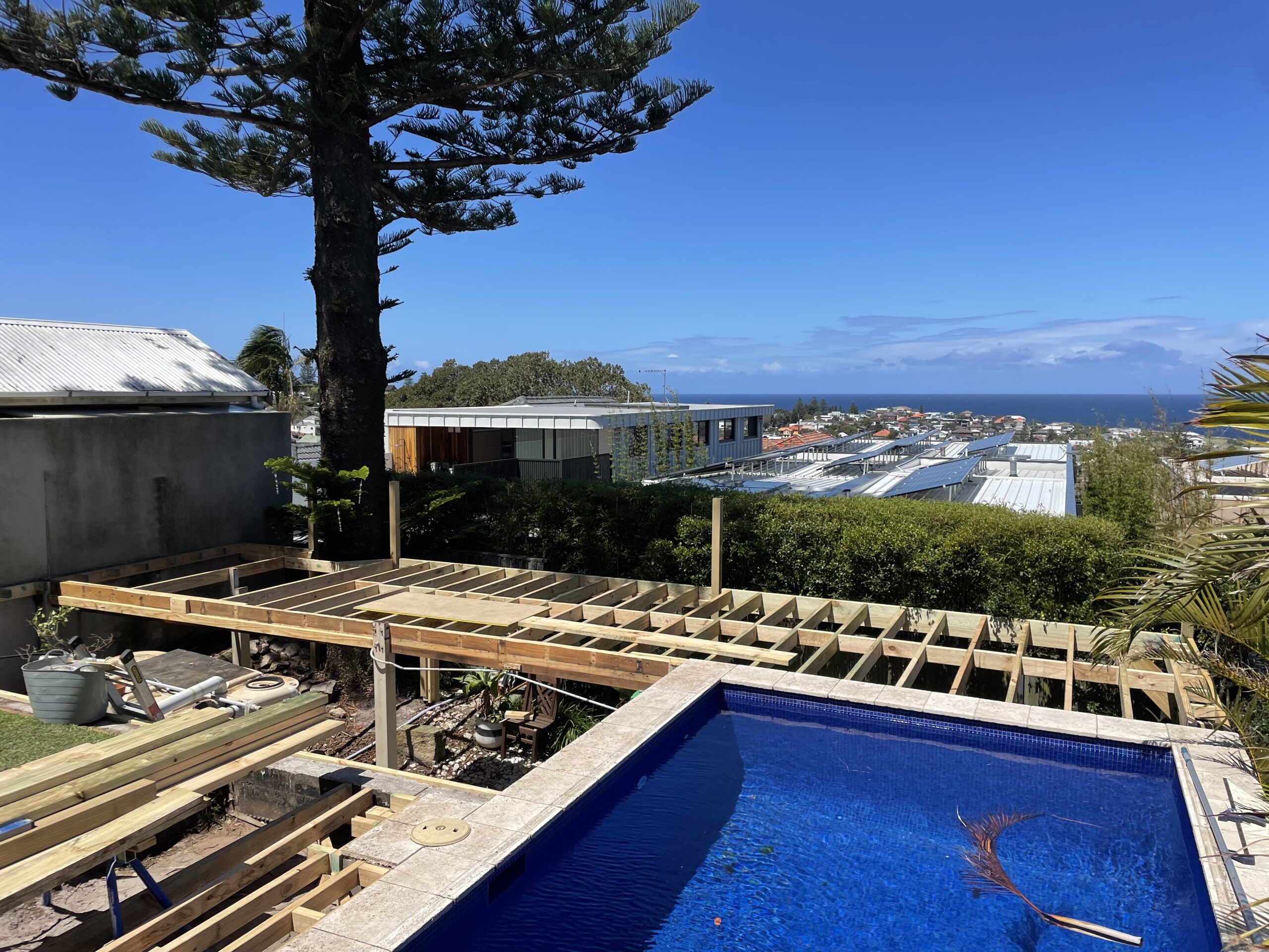 Framing progress with elevated site view, Clovelly pool deck — The Decksmith