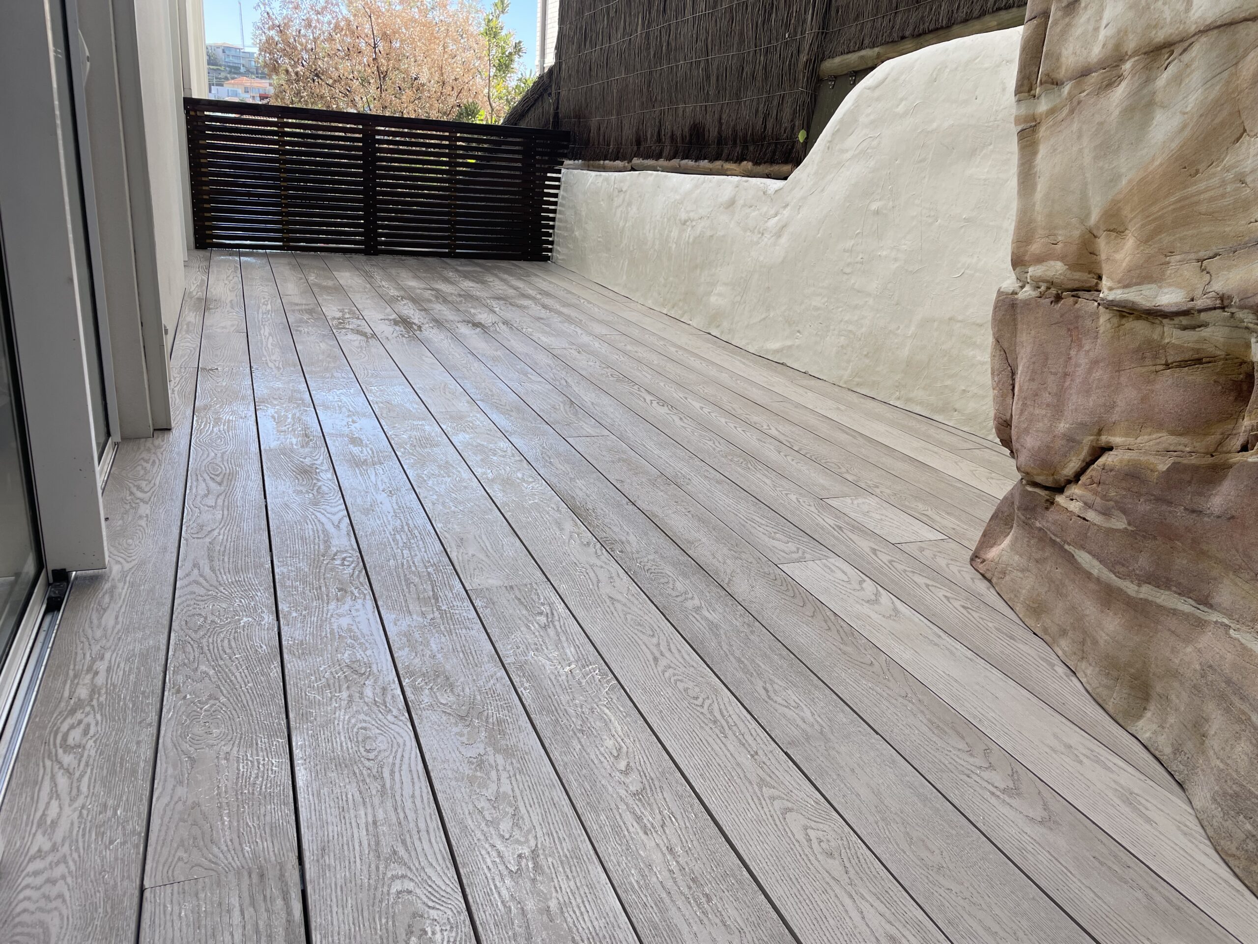 Millboard Limed Oak Coogee Lowdeck pedestals and secret scribe That’s sexy — rock-scribed Millboard Limed Oak deck in Bronte