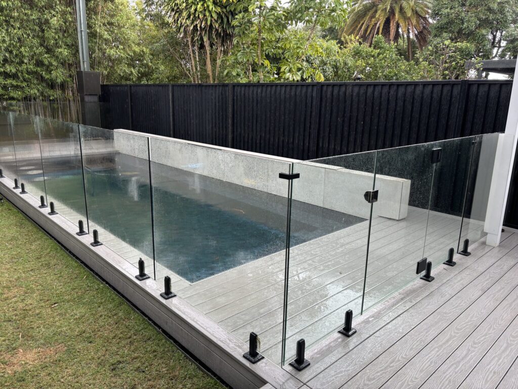 Glass fence installed, done — Kingsford WoodEv pool deck complete