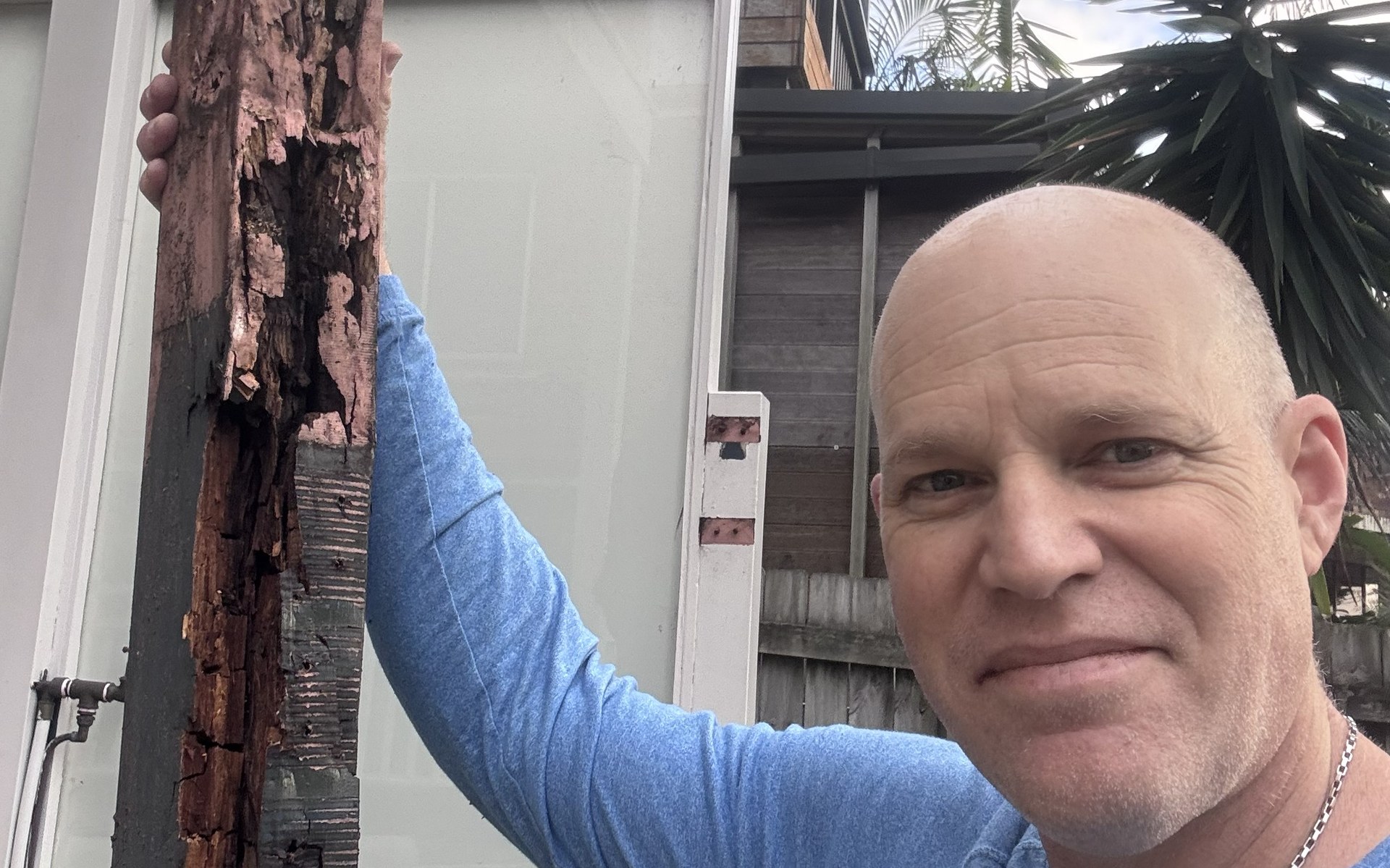 Sydney deck builder Greg holding a rotten deck post showing structural failure underneath