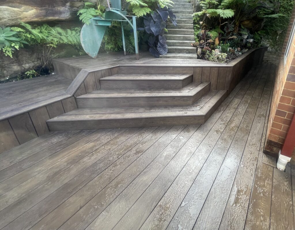 Millboard Antique Oak deck with built-in bench and timber-look stairs at Northbridge