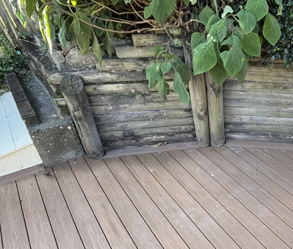 Composite deck boards scribed around round log poles of the retaining wall, Double Bay