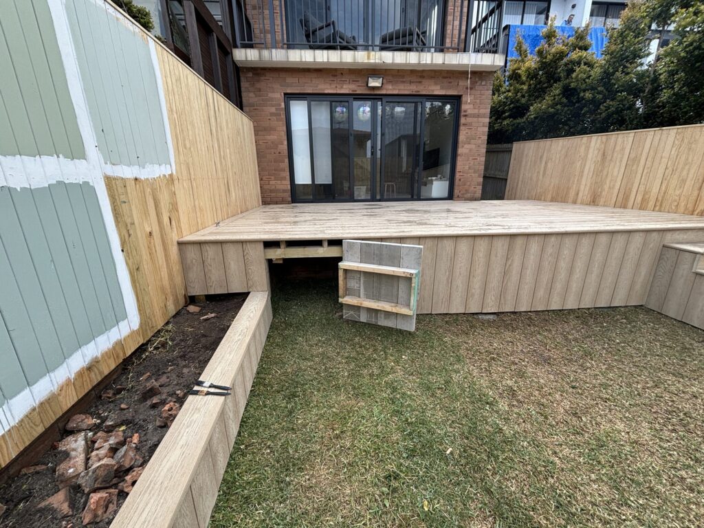 Under deck storage hatch open showing the full storage void beneath the deck
