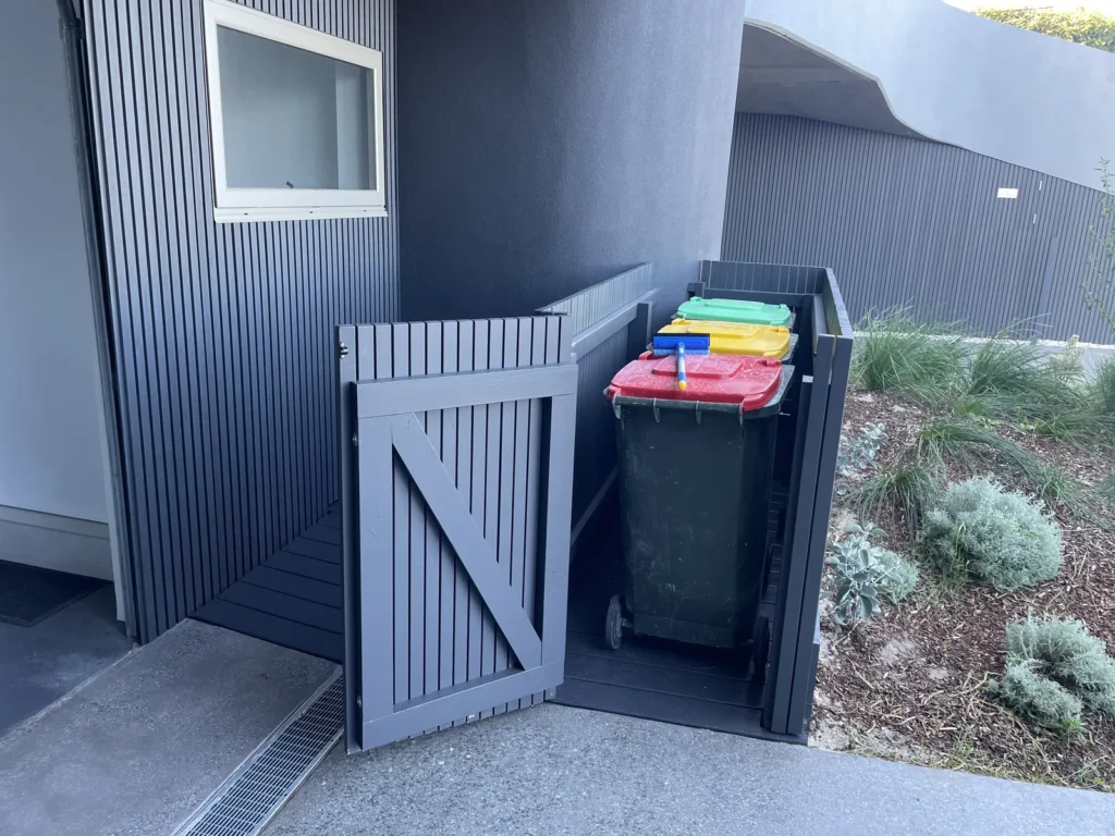 Gate open on the Mons Avenue Maroubra bin store showing three wheelie bins inside