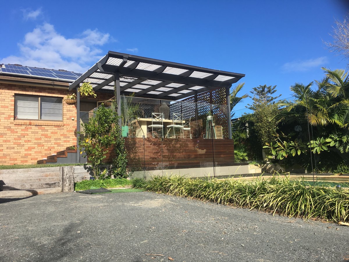 Dark-framed polycarbonate pergola with glass balustrade